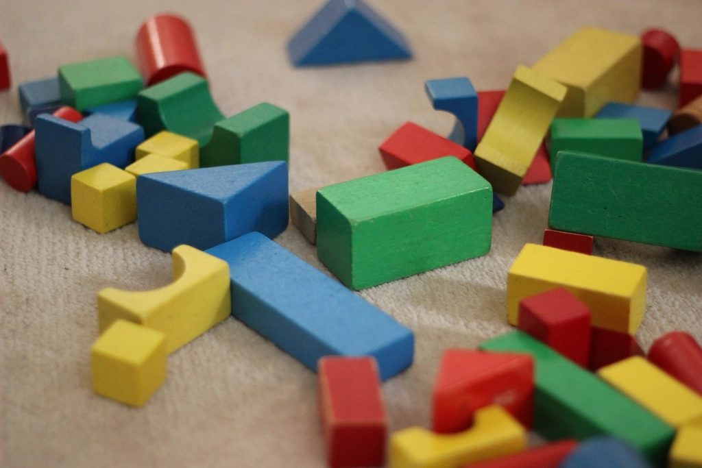 Kind spielt mit Holzbausteinen